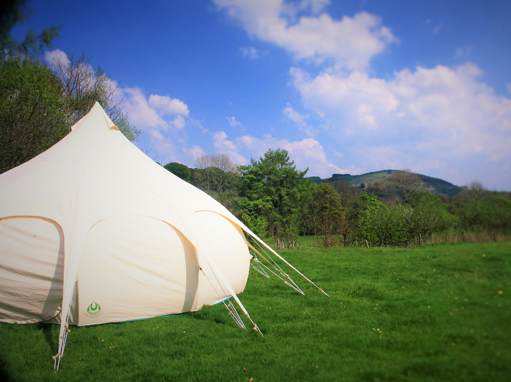 Lotus Belle Tent (a distinctive type of glamping tent) with the view from Tyn Cornel Camping
