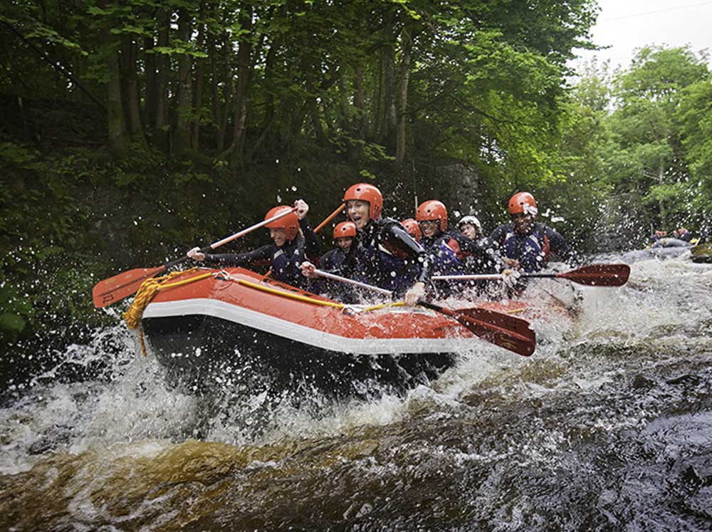 A group enjoying white water rafting on the River Tryweryn, Snowdonia National Park