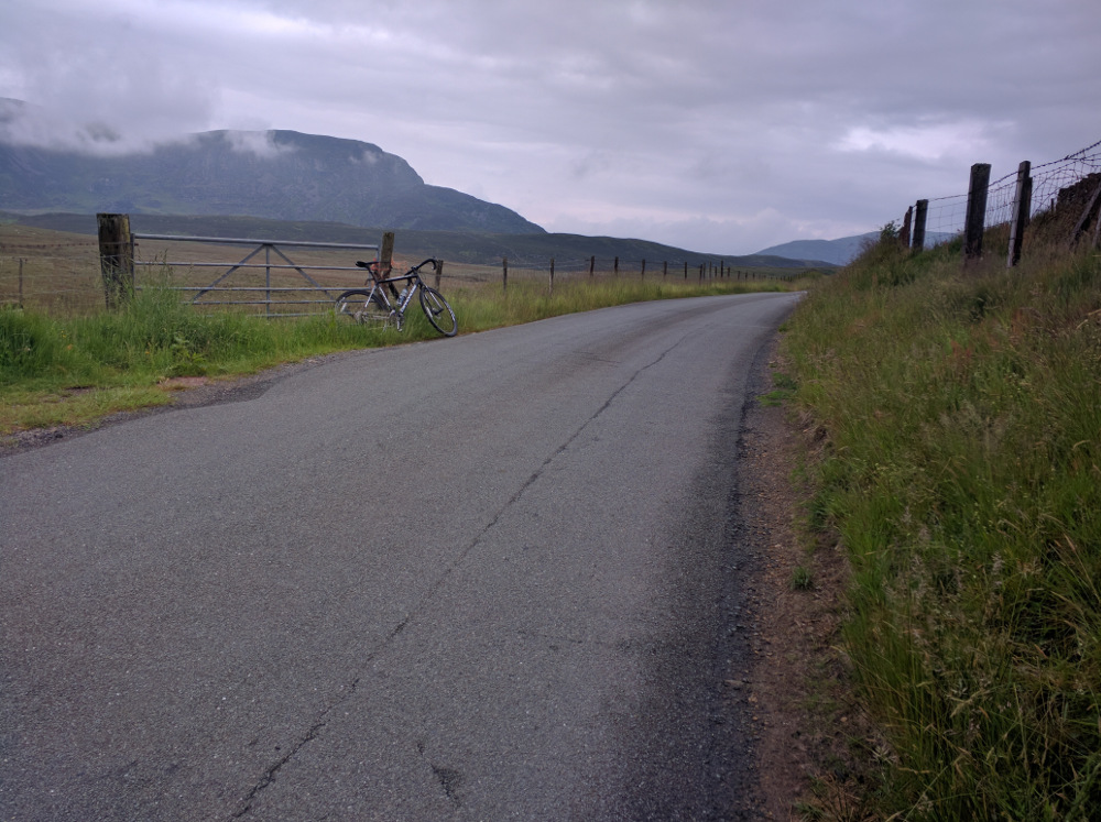 A view of Arenig Fawr shrouded in cloud with a road bike in the foreground